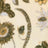 Blurry close-up of a floral pattern on beige fabric, featuring green and yellow vintage-style flowers and leaves.