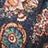 Close-up of a vibrant fabric featuring floral and circular patterns in shades of blue, orange, and cream.