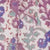 Close-up of a fabric featuring a vibrant floral pattern in purple, green, and blue hues.