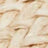 Close-up view of a woven, light tan material, possibly straw or rattan, showing a textured, interlaced pattern.