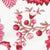 A fabric pattern featuring pink and red botanical elements, including berries and leaves, set against a white background.