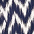 Close-up of a fabric featuring a navy blue and white chevron ikat pattern.