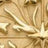 Close-up of an embossed, decorative gold surface with intricate floral and leaf patterns in relief, showcasing elegant craftsmanship.