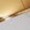 Blurry close-up of a light-colored surface with part of a dark object and a soft beige hue.