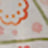 Blurry image displaying abstract shapes in red, orange, and green tones, possibly part of a patterned fabric or unique artwork.