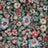 A blurred, colorful pattern featuring various small, indistinct floral shapes in shades of red, pink, white, and green.