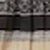 A blurred image with horizontal sections in black, gray, and beige tones; patterned texture is visible at the top.