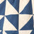 A fabric with a geometric pattern of blue and white triangles arranged in a repeating grid.
