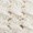 Close-up of animal footprints pressed into light-colored sand, highlighting the delicate patterns left behind.
