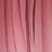 Close-up of pink fabric with vertical folds and creases.