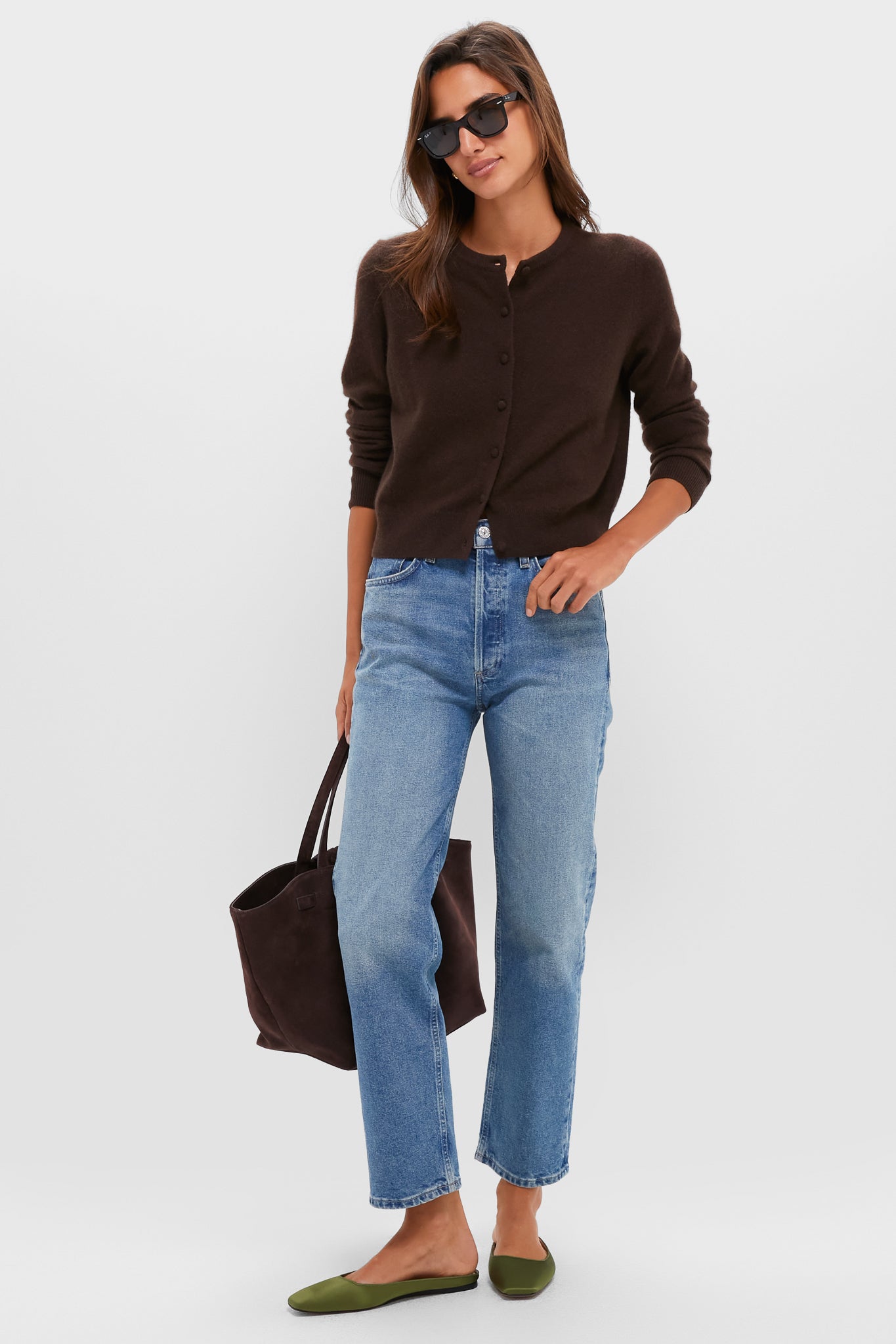 Woman wearing Fern Satin Nilli Flats, featuring a classic mule silhouette and square toe, styled effortlessly with jeans and a cardigan, epitomizing fun, high-end fashion.