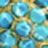 A blurred close-up image shows multiple round blue objects against a shimmering gold setting.
