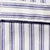 Close-up of fabric with blue vertical and horizontal stripes on white, featuring part of a pocket.