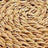 Close-up view of coiled, thick, natural fiber rope arranged in a circular pattern, showcasing its rustic texture.