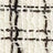 Close-up of a textured fabric with a white background and a black checkered grid pattern.