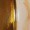 A close-up view of a wooden door slightly ajar, showing part of the door frame in soft lighting. The craftsmanship of the wood is highlighted by the gentle illumination.
