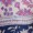 A close-up of clothing tags on a floral fabric item, featuring sizing information and care instructions for stylish wear.
