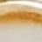 A blurry close-up image with indistinct brown and beige areas near the top and a lighter gradient at the bottom.