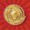 A gold medal with a laurel wreath design gleams against a red, radiating glow.