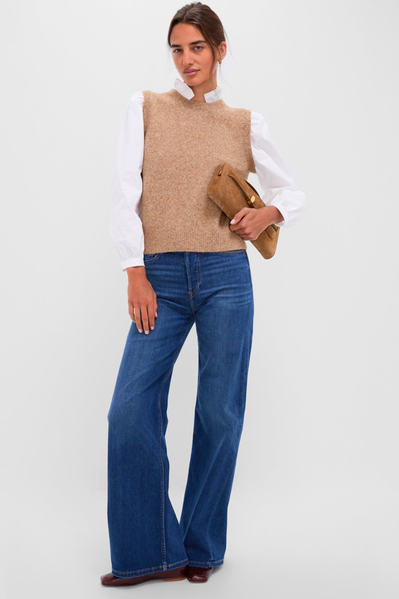 Model wearing the Desert Melange Ella Sweater Blouse, effortlessly layered over a blouse, paired with wide-leg jeans, and holding a camel-suede clutch for a classic, high-end look.
