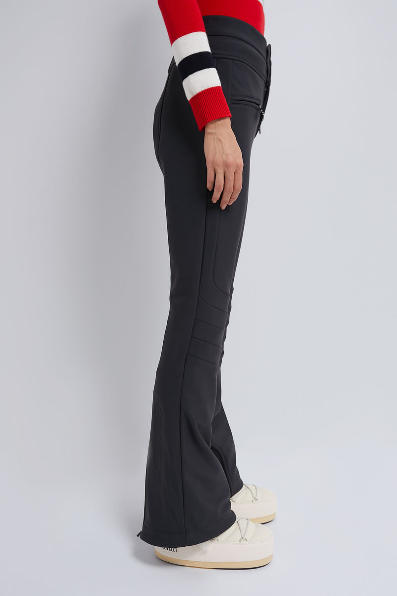 Side-profile of Black Aurora High Waist Ski Pant with zip pockets and seam detailing, styled with cream platform boots, embodying classic, effortless, and high-end ski fashion.