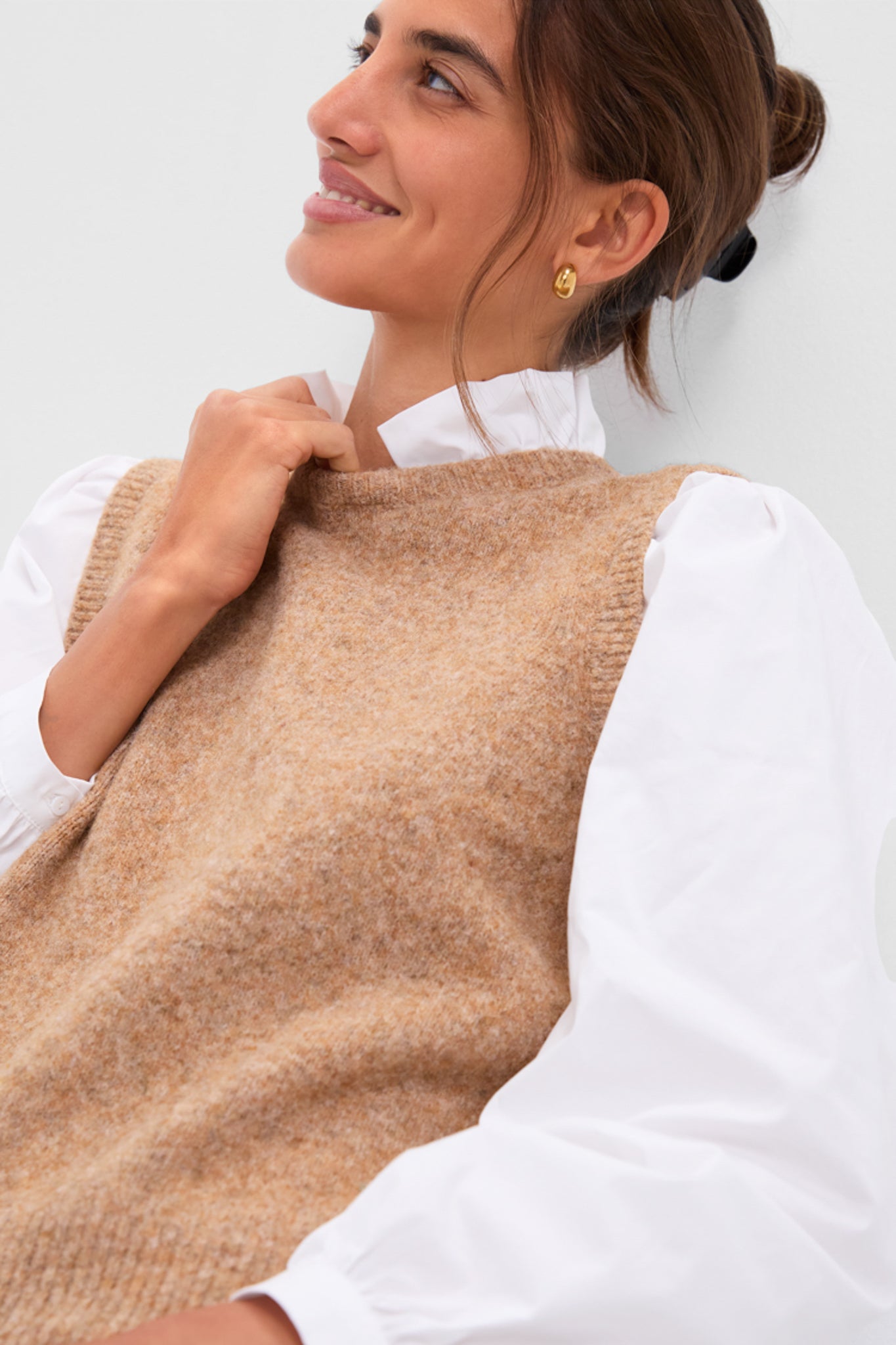 Young woman in the Desert Melange Ella Sweater Blouse: a classic, effortless high-end look with a chic sweater vest, ruffle collar, and puffed sleeves.