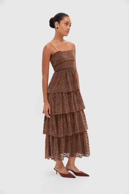 Sepia Lace Leina Midi Dress features a classic, effortless tiered design with spaghetti straps, styled with gold hoop earrings and mules, embodying a high-end, fun aesthetic.