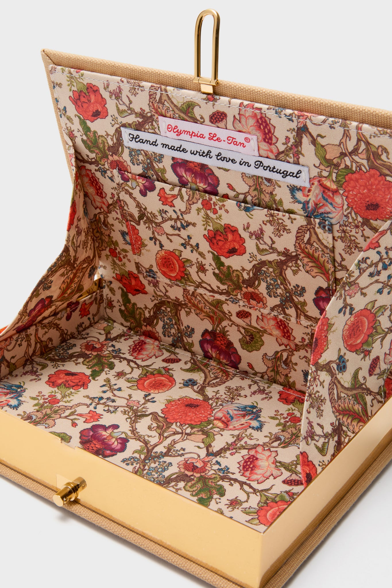 Latte Les Chiens Caramel Book Clutch features a classic, high-end design with a vintage floral lining and hand-embroidered details, effortlessly blending fun and elegance.