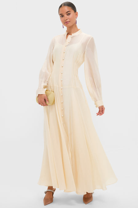 Woman in a flowing dress models Mocha Satin Mae Heels, featuring a chic satin pointed toe and sparkling ankle strap, embodying classic, effortless, high-end style.