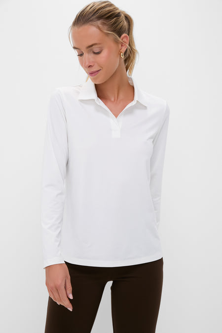 A woman wearing a Tnuck Sport white slim fit polo crafted from quick dry performance fabric.