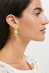 Side profile of a woman wearing Gold Trumbull Earrings: classic gold oval studs with a central pearl, exuding effortless elegance and high-end style.