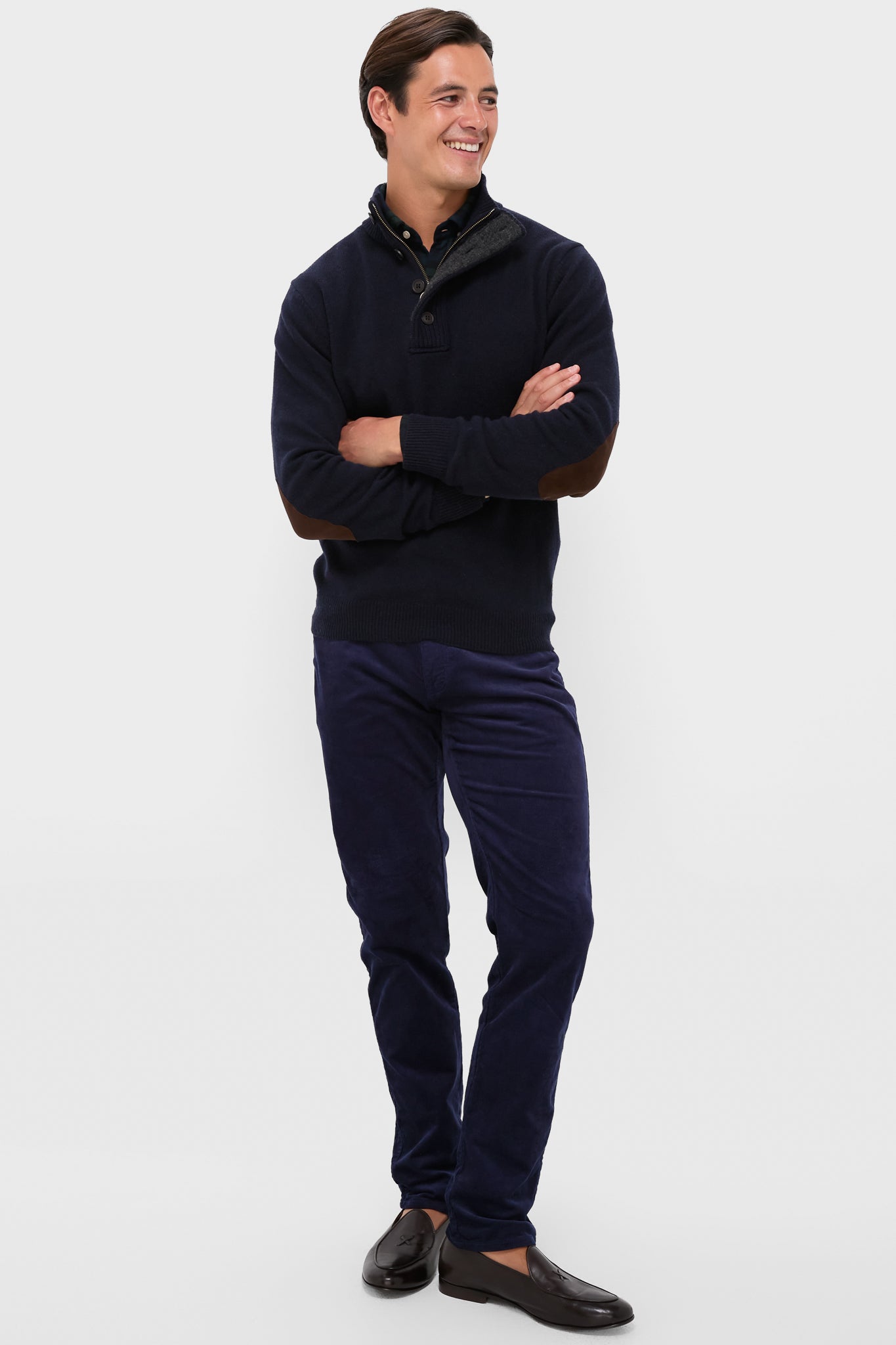 Man models the classic Navy Essential Patch Half Zip Knitted Jumper with suede elbow patches, paired effortlessly with tailored corduroy trousers and loafers for a high-end, fun look.