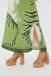 Ireland Green Wess Midi Dress features a chic botanical-print, side slit, and tan woven platform heels, embodying effortless elegance and classic high-end style for fun occasions.
