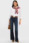 Model wearing a classic, effortless look with the Maraschino and Biscotti Belt, paired with a white shirt, floral scarf, indigo jeans, and suede accessories.