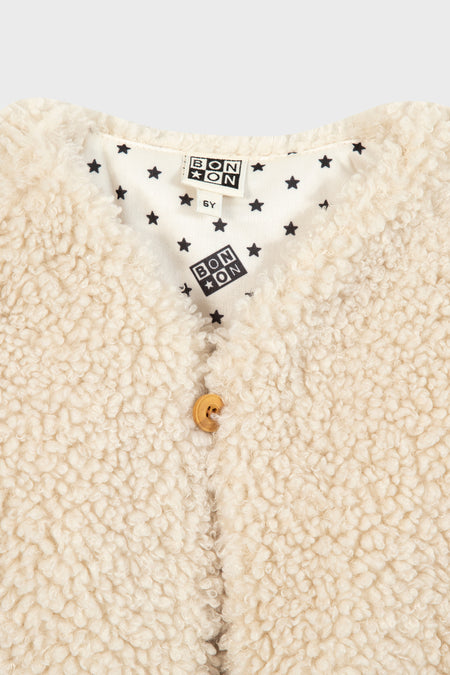 Cream Teddy Vest with curly fleece, a classic single-button closure, and fun star-patterned lining, embodies effortless, high-end style for your child's wardrobe.