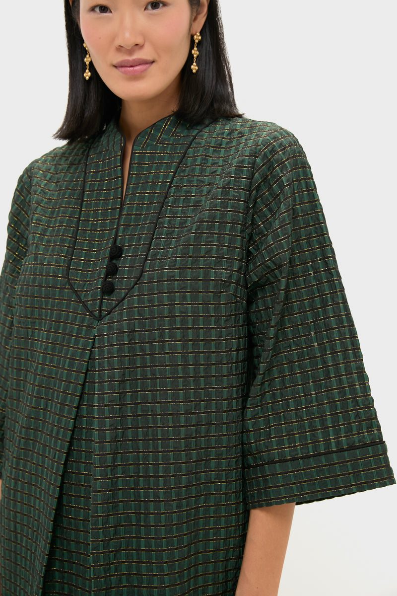 Woman wearing the classic Metallic Green Plaid Indy Maxi Dress with gold accents, featuring a mandarin collar and black piping, exuding effortless, high-end style.