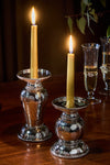 Graham 5 Pillar/Taper Candle Holder: classic hammered-metal design, supporting lit taper candles on a stylish tabletop with champagne flutes, offering an effortless, fun, high-end ambiance.
