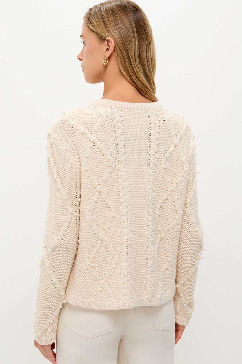 Woman wearing the Cream Cable Knit Pearl Collins Cardigan, showcasing its classic, high-end cable-knit pattern with faux pearls, embodying effortless style and fun sophistication.