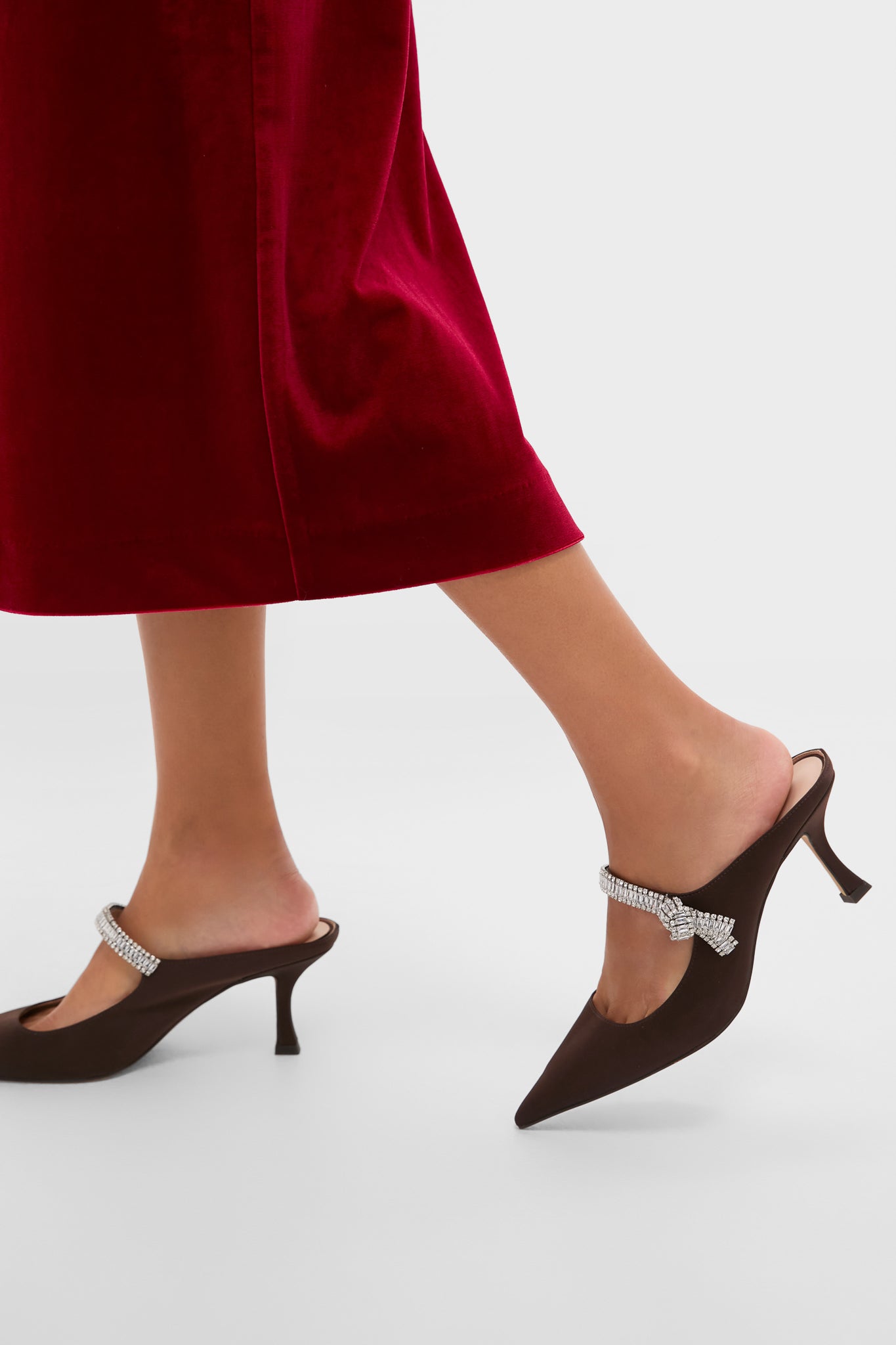 Chocolate Satin Mae Heels exude classic elegance with their dark brown satin finish, effortless pointed-toe design, and fun, high-end crystal-embellished strap. Perfect for glamorous occasions.