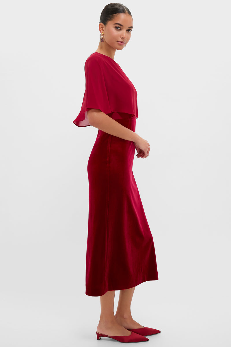 Model in profile wearing classic Cranberry Velvet Chiffon Mixed Media Cape Leah Dress, featuring an effortless capelet top, velvet skirt, and matching red mules, exuding high-end, fun elegance.