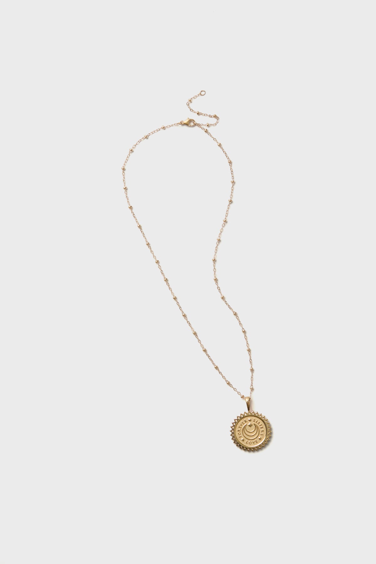 Jane Win gold necklace featuring a delicate chain and a round, engraved sun medallion pendant—ideal for layering or gifting to your Gold Sisters Forever.