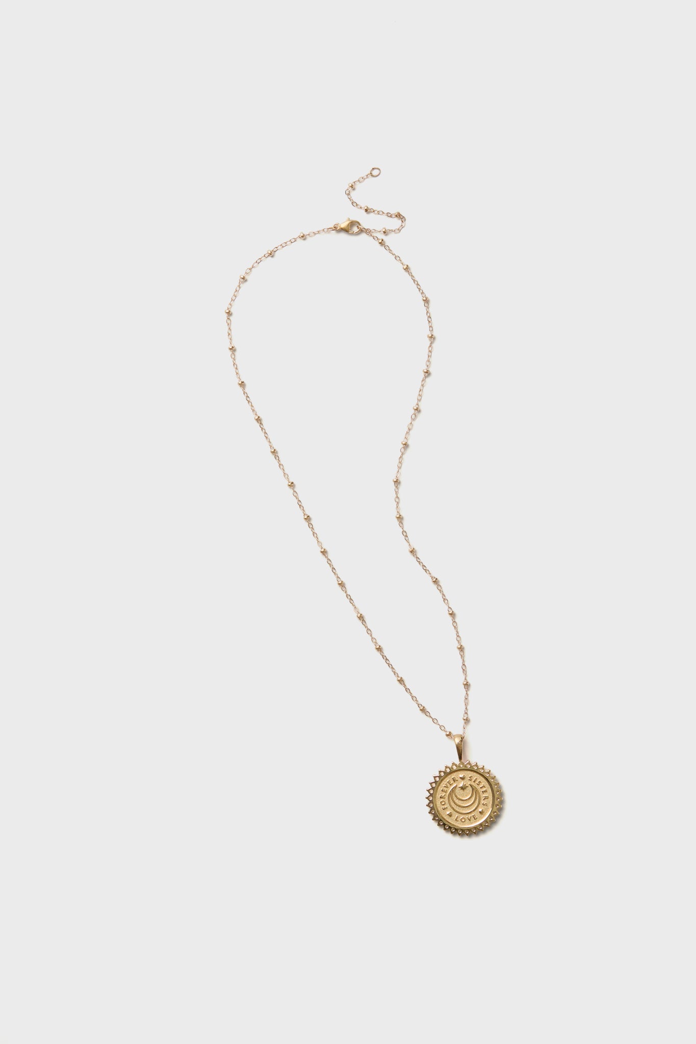 Jane Win gold necklace featuring a delicate chain and a round, engraved sun medallion pendant—ideal for layering or gifting to your Gold Sisters Forever.