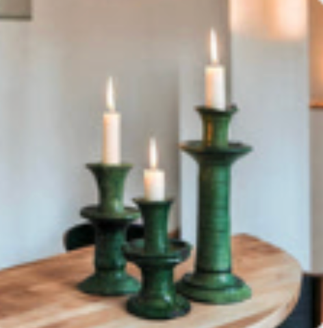 Three green ceramic candle holders of different heights from Tuckernuck Vintage Accessories, each with a lit white candle, displayed on a wooden surface.