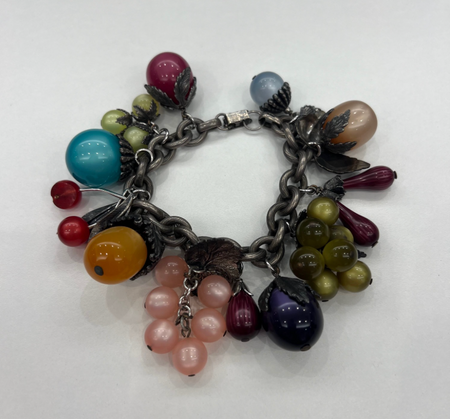 A silver charm bracelet by Tuckernuck Vintage Accessories features colorful glass beads shaped like grapes, cherries, and berries arranged in clusters.
