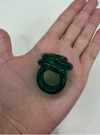 A hand displays three stacked dark green translucent rings from Tuckernuck Vintage Accessories against a plain light background.