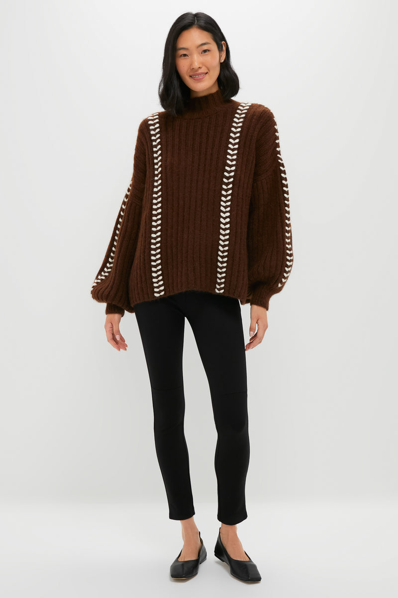 Model wearing the classic Brown Mayu Sweater with mock neck and balloon sleeves, paired effortlessly with black leggings for a high-end, fun look.