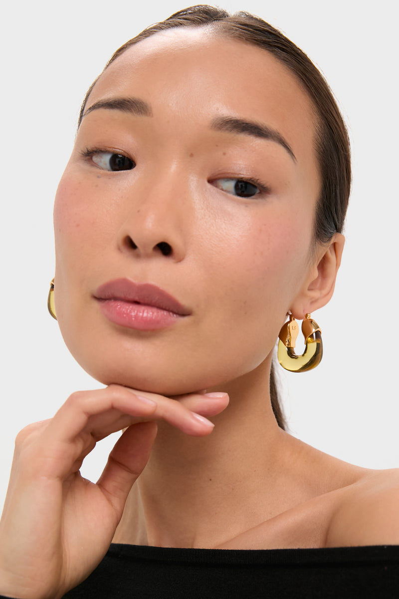 Young woman wearing Apple Organic Hoops, chunky polished gold earrings, exuding classic, effortless elegance. Perfect for fun, high-end styling with various outfits.