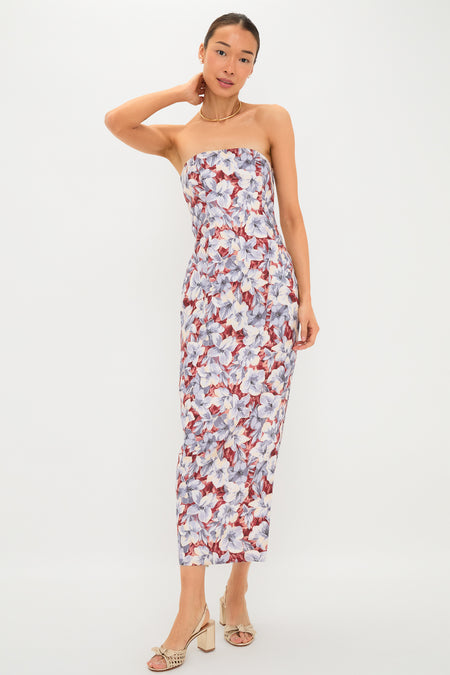 POSSE woman in a strapless linen dress featuring a purple, white, and red floral pattern, styled with cream heeled sandals—a chic pick for sunny days and special occasions.