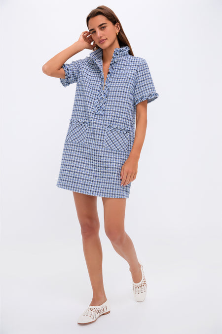 A woman stands in a Pomander Place Blue Tweed Ophelia Dress with a shift silhouette and front pockets, paired with white woven shoes, against a neutral background.