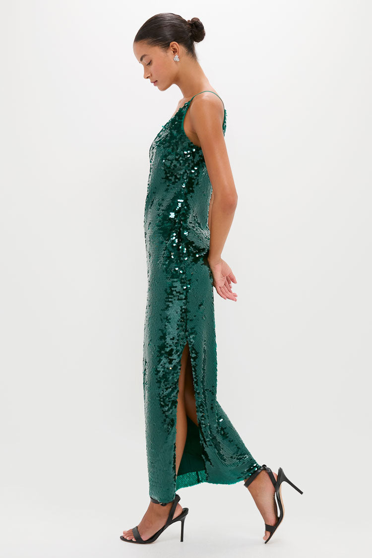 A woman in a Saylor emerald sequin midi dress with a side slit and black high-heeled sandals stands against a plain white background.